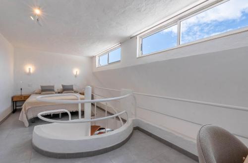 a white bedroom with a bed and a window at Private Jacuzzi & vista al mar in Mogán