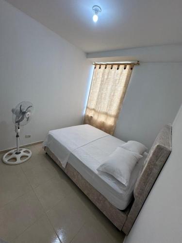 a bedroom with a bed with a window and a fan at Apartamento Entresierras 3 hab con AC -un hogar lejos de casa in Valledupar