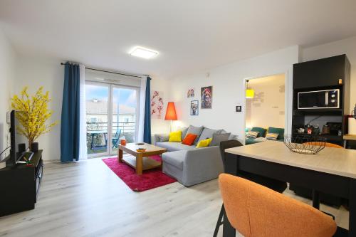 un salon avec un canapé et une table dans l'établissement Vitamine - Services sur-mesure et Parking Gratuit, à Saint-Jean