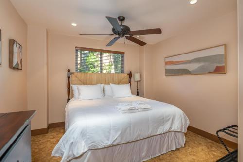 a bedroom with a white bed with a ceiling fan at Wilsons Roost in Dorrington
