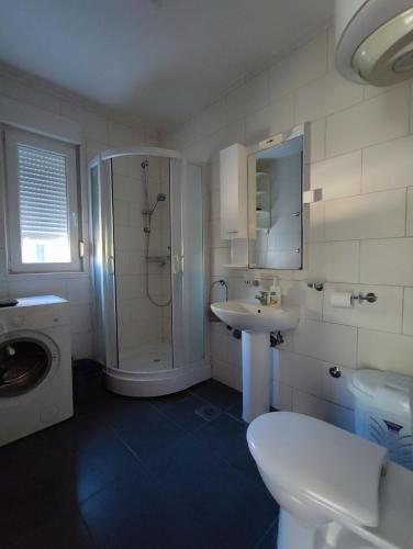 a bathroom with a shower and a sink and a toilet at PRCPORTOapartmani in Herceg-Novi