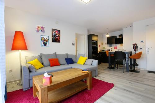 un salon avec un canapé et une table dans l'établissement Vitamine - Services sur-mesure et Parking Gratuit, à Saint-Jean