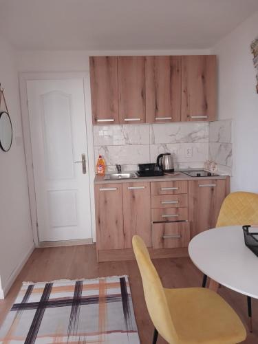a kitchen with wooden cabinets and a table and chairs at PRCPORTOapartmani in Herceg-Novi