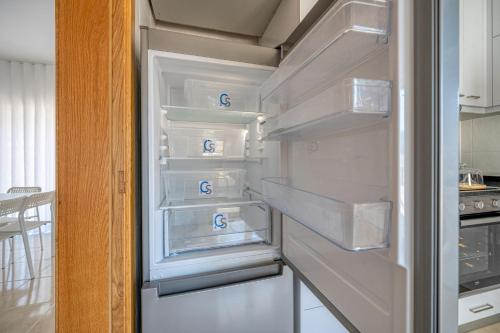 an empty refrigerator with its door open in a kitchen at Central Suites Arouca in Arouca
