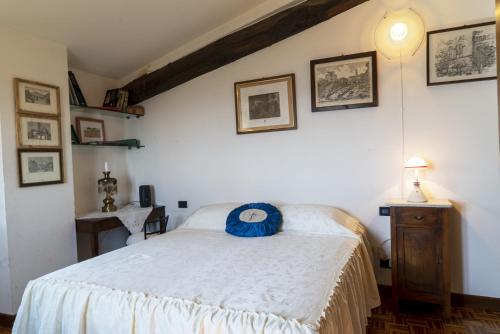 a bedroom with a bed with a blue pillow on it at Country Historical House Lucca in San Gennaro
