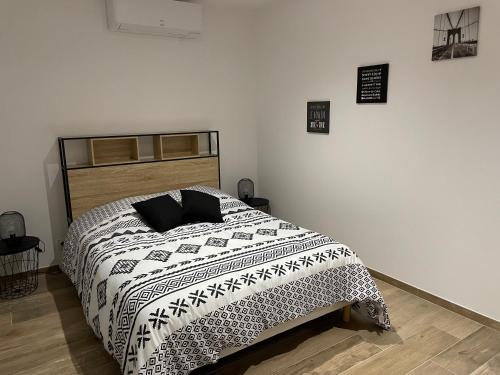 une chambre avec un lit avec une couette noire et blanche dans l'établissement gite LE MONT MARSIS, à Gourdon