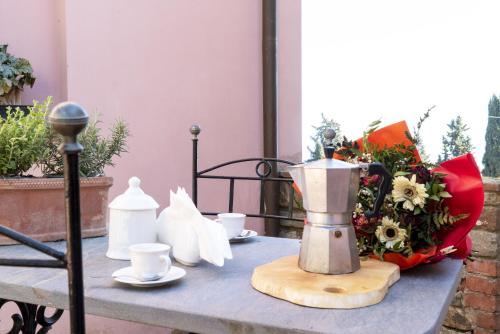 a table with a blender and cups and a bouquet of flowers at Country Historical House Lucca in San Gennaro
