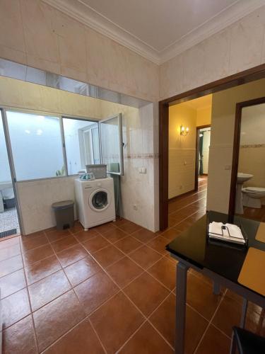 a bathroom with a washing machine in a room at Casa São Salvador in Angra do Heroísmo
