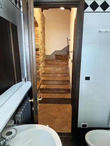 a bathroom with a toilet and stairs in the background at Country Historical House Lucca in San Gennaro