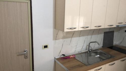 a kitchen with a sink and white cabinets at Kris's Studio in Lezhë
