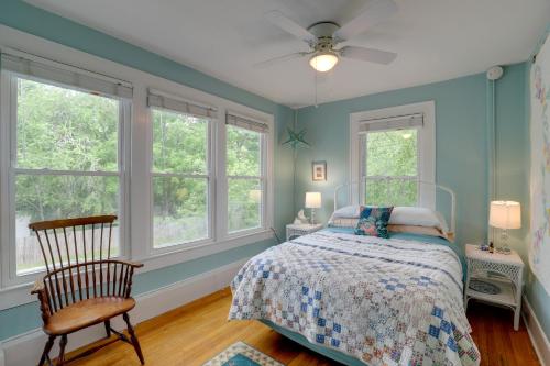 亨德森维尔Lovely Hendersonville Retreat about 1 Mi to Downtown!的一间卧室设有蓝色的墙壁和一张带椅子的床