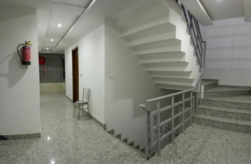 a staircase in a building with a chair in a hallway at Hotel Neu-Nest inn in Rishīkesh