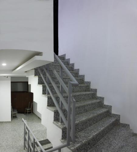 a staircase in a building with a white wall at Hotel Neu-Nest inn in Rishīkesh