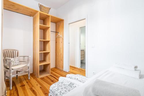 a bedroom with a bed and a chair and a window at Casa Brisa in Altea