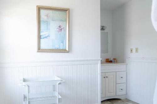a kitchen with white cabinets and a picture on the wall at The Gull Oceanside Inn & Motel in Old Orchard Beach