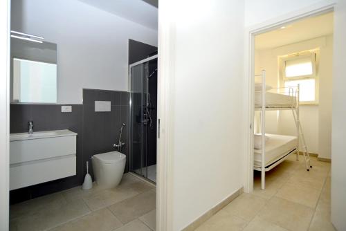 a bathroom with a toilet and a sink and a mirror at Le Luminarie Lido Marini in Lido Marini
