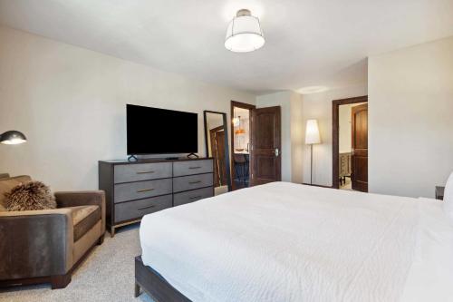 a bedroom with a bed and a tv and a couch at Ascent 312 by East West Hospitality in Avon