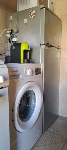 a kitchen with a washing machine and a refrigerator at Casa Verdi Telti in Telti