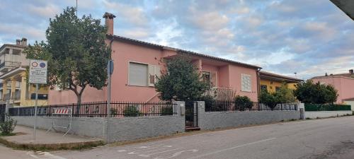 a pink house on the side of a street at Casa Verdi Telti in Telti