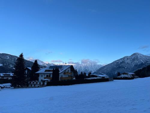 a house in the snow with mountains in the background at Apartment Oberleins I in Arzl im Pitztal