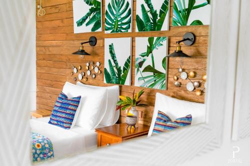 a bedroom with white pillows and a wall with plants at Ponderosa Golf and Resort in Puerto Galera