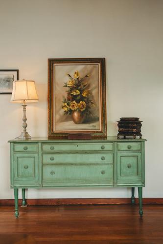 a green dresser with a painting on top of it at La Villa de Adelina in Ensenada