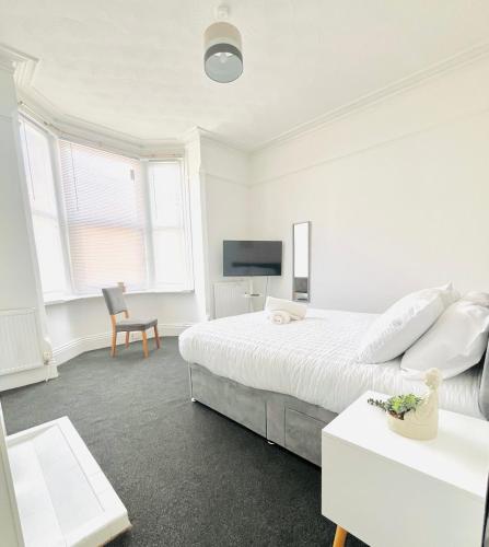 a white bedroom with a bed and a tv at Francis Avenue in Portsmouth