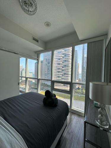 a bedroom with a bed and a large window at Newly updated 3BR, 2Bath in Downtown Toronto beside Union Station & Scotia Bank Arena! in Toronto