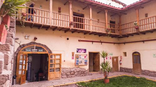 an old house with a balcony and a courtyard at Loki Cusco in Cusco