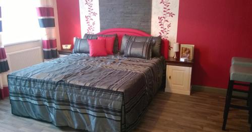 a bedroom with a large bed with red walls at Lutherdom Apartment in Lutherstadt Eisleben