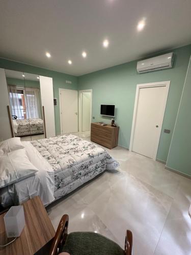 a bedroom with a bed and a table and a tv at Karim's House in Portici