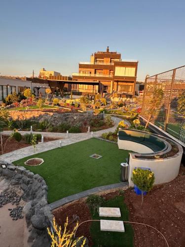 a garden with a large building in the background at Kinda vip in Al Mashāriqah