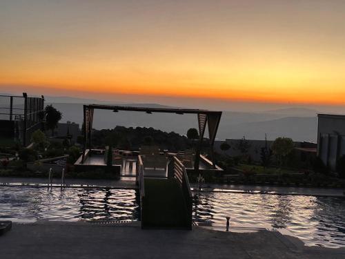 a view of a pool with a sunset in the background at Kinda vip in Al Mashāriqah