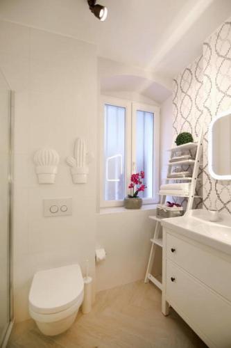 a white bathroom with a toilet and a sink at Magic Rooms Split in Split
