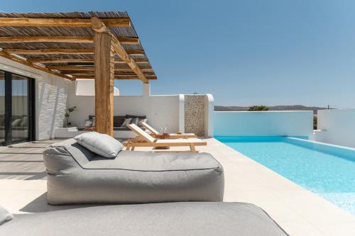 a living room with a couch and a swimming pool at plaka riviera villa in Naxos Chora