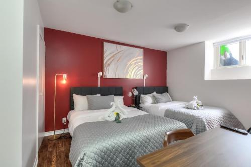 two beds in a room with red walls at Fox Aparthotel - Palais Des Congres in Montréal