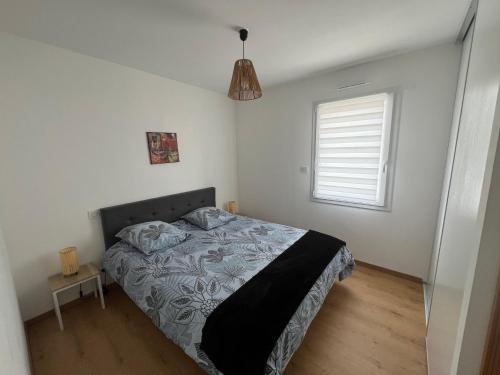 Grandchamp-des-FontainesにあるMaison 3 pièces - plain pied - 2 chambres lits Queen Size avec wifiのベッドと窓のある寝室