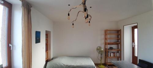 a bedroom with a bed and a chandelier at Studio Salavas in Salavas