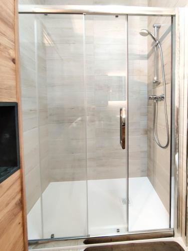 a shower with a glass door in a bathroom at Amber Court Apartment in Marsaskala