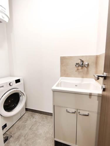 a bathroom with a sink and a washing machine at Amber Court Apartment in Marsaskala
