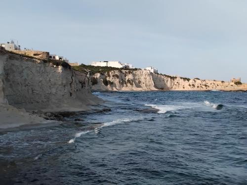 a body of water next to a rocky coast at Amber Court Apartment in Marsaskala