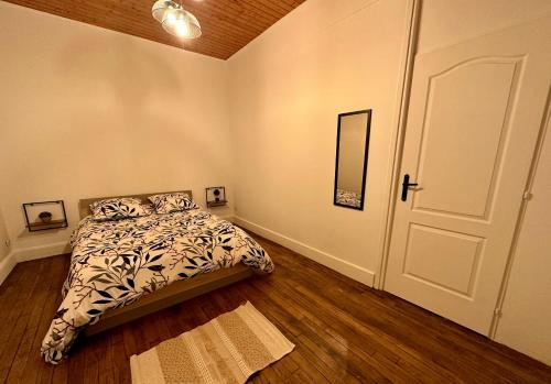 - une chambre avec un lit et une porte avec un miroir dans l'établissement Le Nid Dijonnais, à Dijon