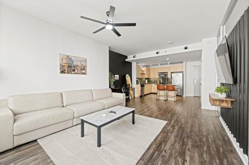 a living room with a white couch and a table at Modern Downtown Dallas City View High-Rise with Balcony, Gym, Pool, Free Parking 7th Floor in Dallas