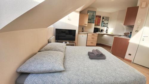 Un dormitorio con una cama con un par de zapatillas. en MAGELLAN Studio proche Loire et CHU, en Nantes