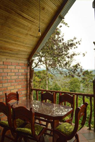a patio with a table and chairs on a porch at Cabañas La Muralla in San Agustín