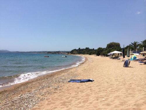 a sandy beach with umbrellas and the ocean at Finiki Plaza in Methoni