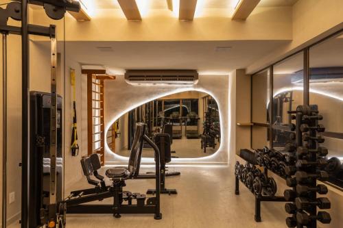 a gym with an arched doorway and a mirror at Ritz Suites Grand Hotel Boutique in Maceió