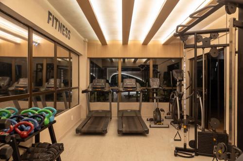 a gym with treadmills and machines in a room at Ritz Suites Grand Hotel Boutique in Maceió