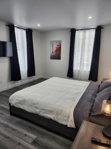 a bedroom with a large bed with black curtains at Auberge Le Cosy Amos in Amos