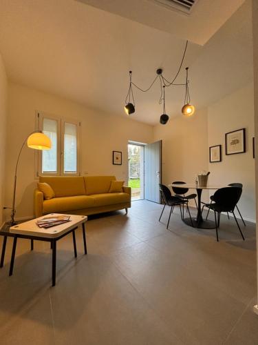 a living room with a yellow couch and a table at Il Giardino Segreto in Faggeto Lario 